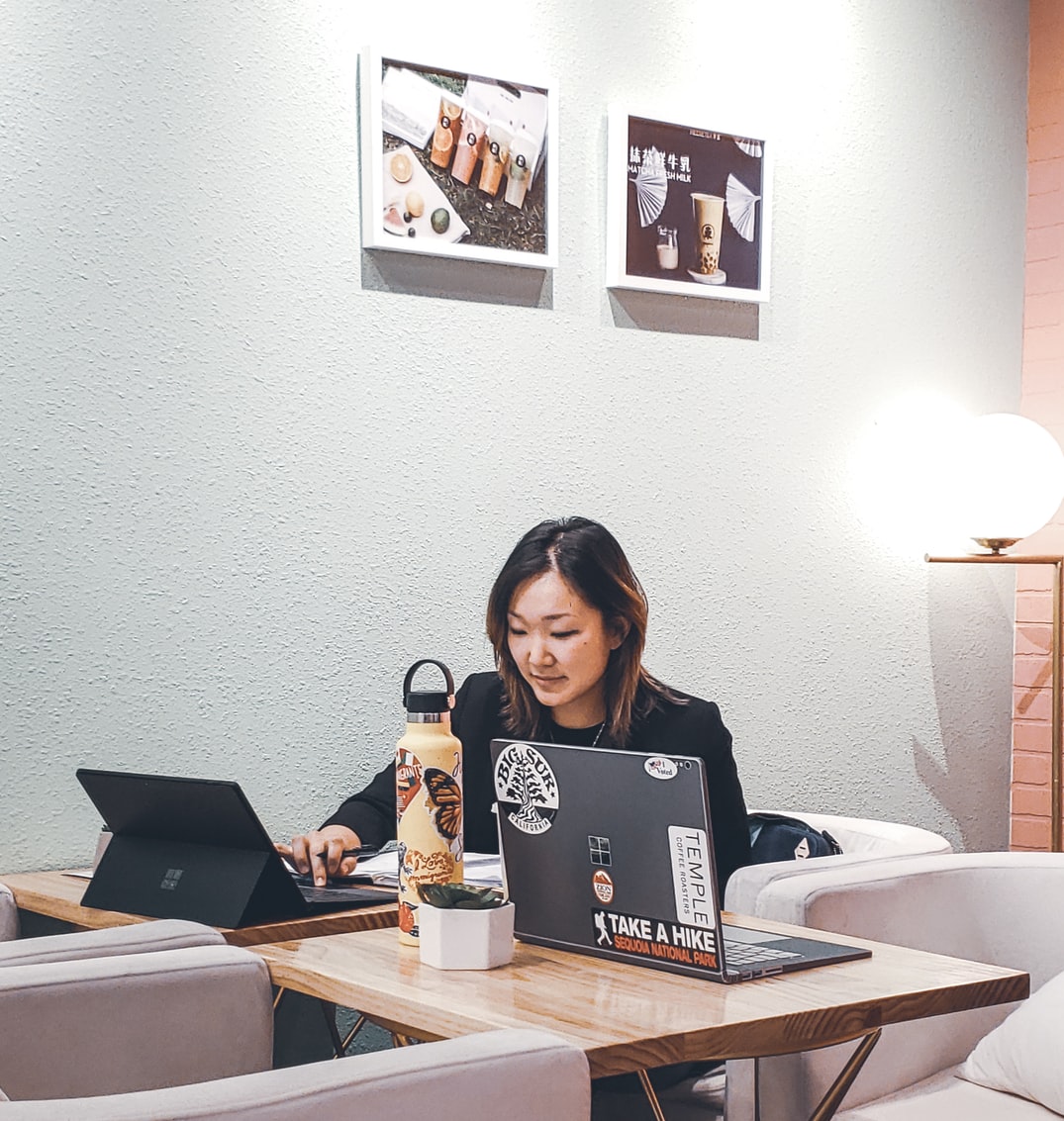 A woman sitting on a chair and working with a laptop on the table