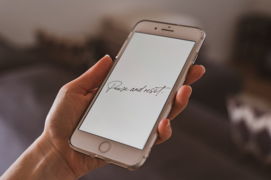 A person holding a silver screen Iphone